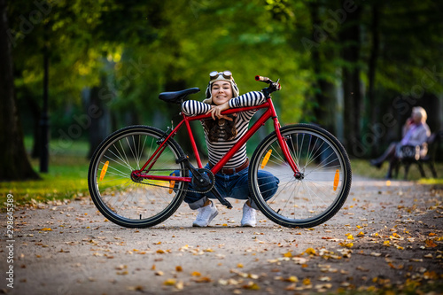 Woman standing with bike in city park