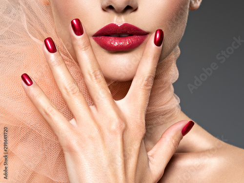 Obraz na plátně closeup face of a  woman with red nails and lips