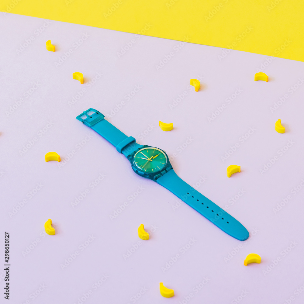 Fashionable blue watches among mini rubber bananas. minimalism Fashionable blue watches among mini rubber bananas. minimalism