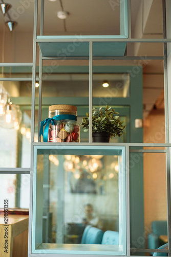 Jar of sweets macarons on the shelf in the interior of the cafe