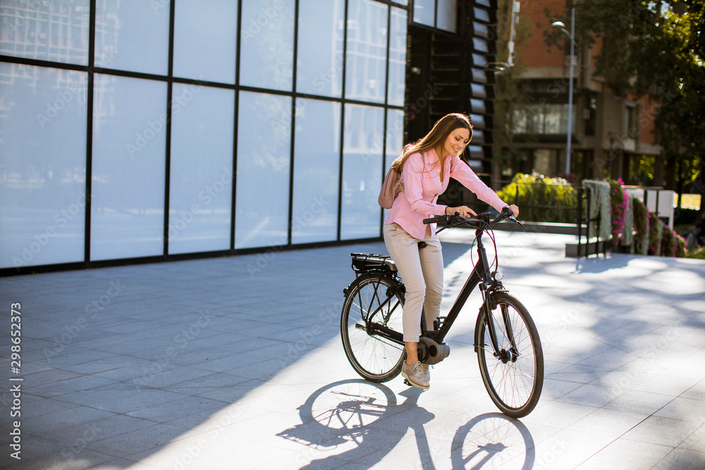 Fototapeta premium Young woman riding an electric bicycle