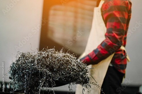 Close up Worker with silver or rusty scrap metal shavings swirls or twisted spiral steel shavings for recycling thing on recycle center. Recycling industry or Business Recycling concept