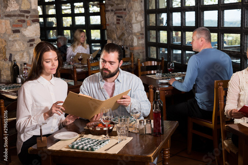 Couple choosing dishes out of menu