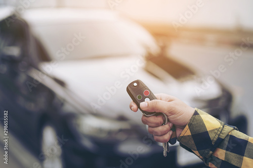 Close up hand of woman presses on the remote control car alarm systems or Car start stop system with finger pressing the button green or red, horizontal image.Technology, Car security system concept