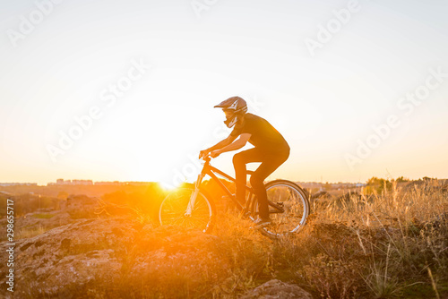 Cyclist on the mountain bike riding at sunset.