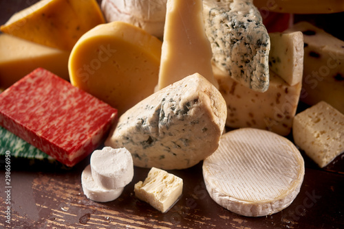 Various types of cheese on rustic wooden table,