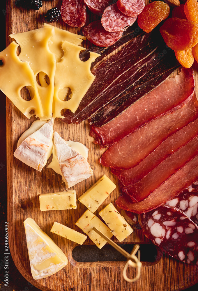 Red wine with different kinds of cheese, charcuterie assortment, crackers, grapes, nuts and berries Red wine with different kinds of cheese, charcuterie assortment, crackers, grapes, nuts and berries