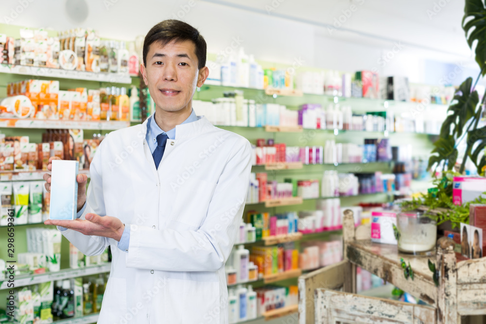 Chinese male pharmacist  posing with medicines in medical shop