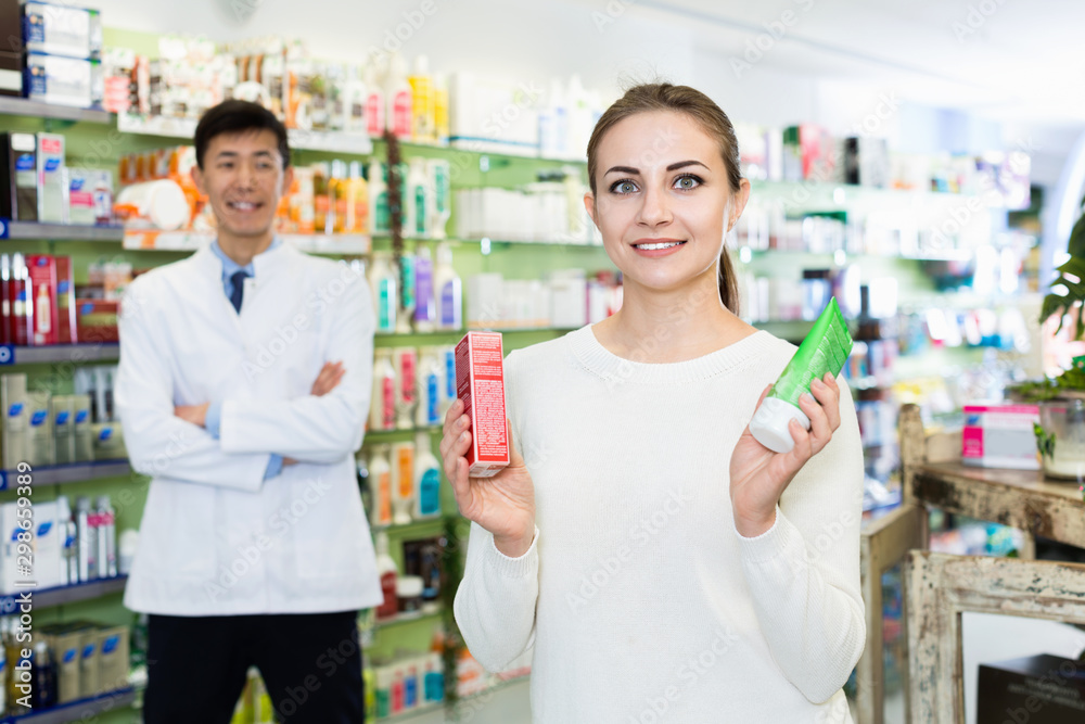 Portrait of woman client who is satisfied of recommended medicines in pharmacy.