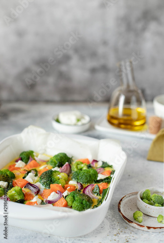 omelette with pumpkin, broccoli and feta on a white dish. healthy food. light background