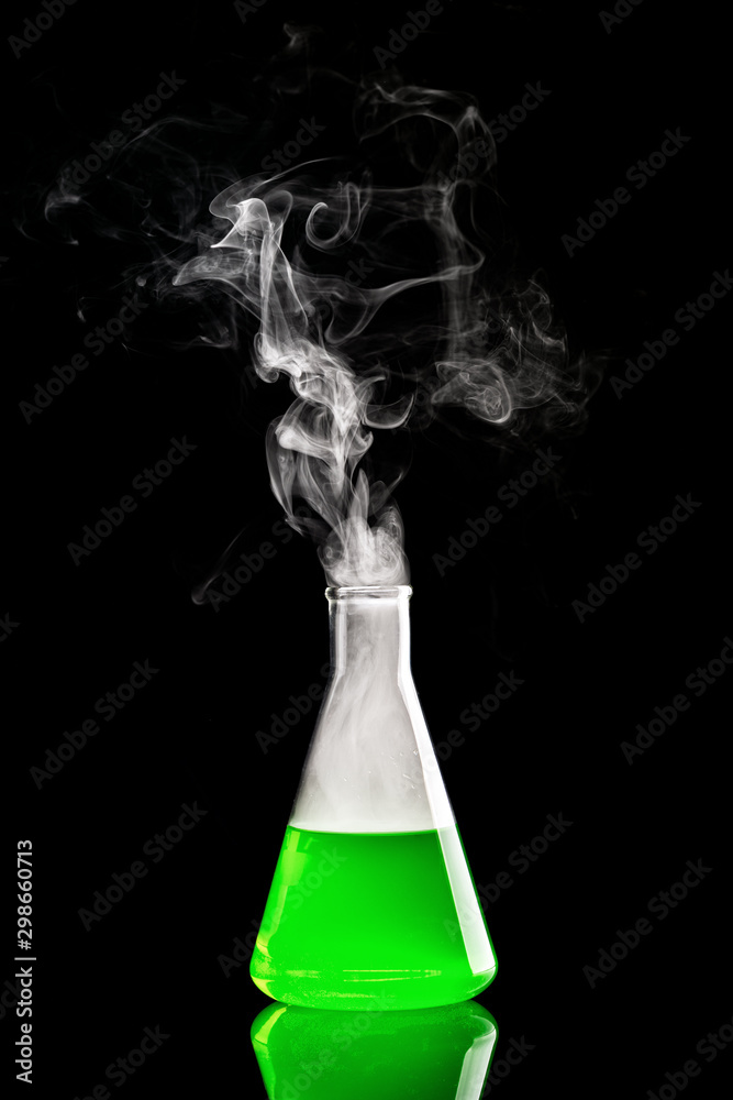 Chemistry experiment with smoke coming from the erlenmeyer flask. Green liquid in flask