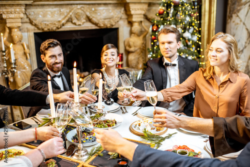 Elegantly dressed people celebrating New Year holiday indoors