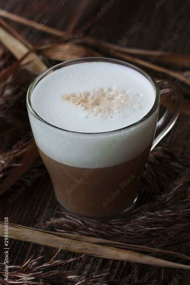Delicious cappuccino with milk on a wooden table Delicious cappuccino with milk on a wooden table