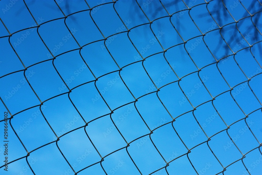 Black metal mesh on the background and blue sky Black metal mesh on the background and blue sky