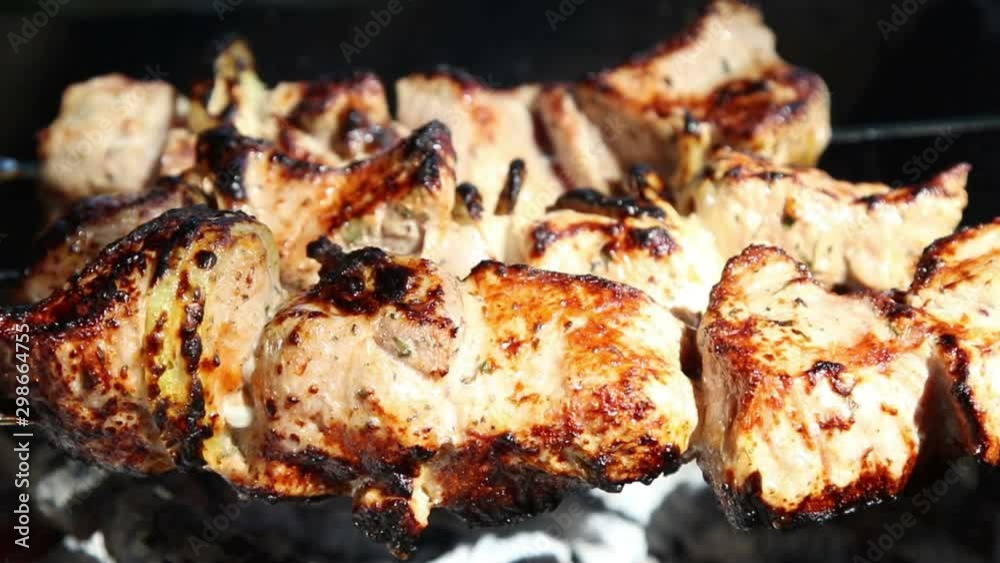 Meat pieces being fried on a charcoal grill. Grilling meat during outdoor recreation. Meat pieces being fried on a charcoal grill. Grilling meat during outdoor recreation.