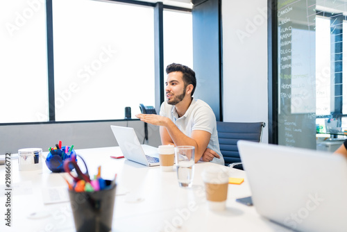 Businessman Using Laptop At Table In Workplace