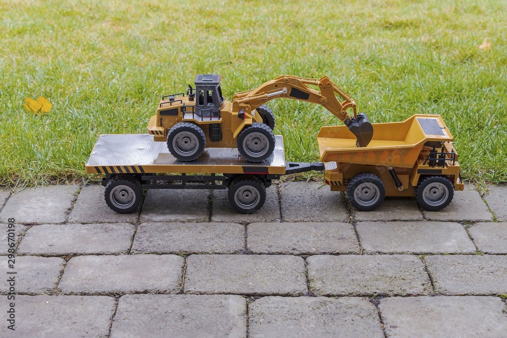View of Radio Controlled  model excavator, dump truck and trailer on  background. Free time Children and adults concept.