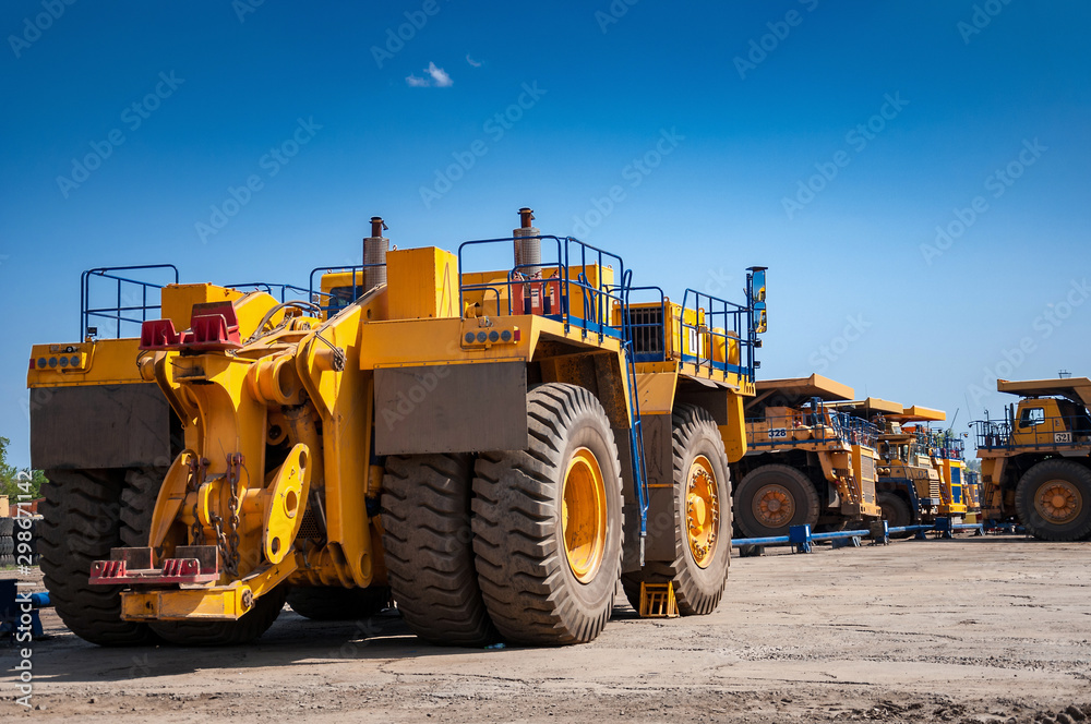Heavy yellow quarry tractor at repair station at sunny cloudless day Heavy yellow quarry tractor at repair station at sunny cloudless day