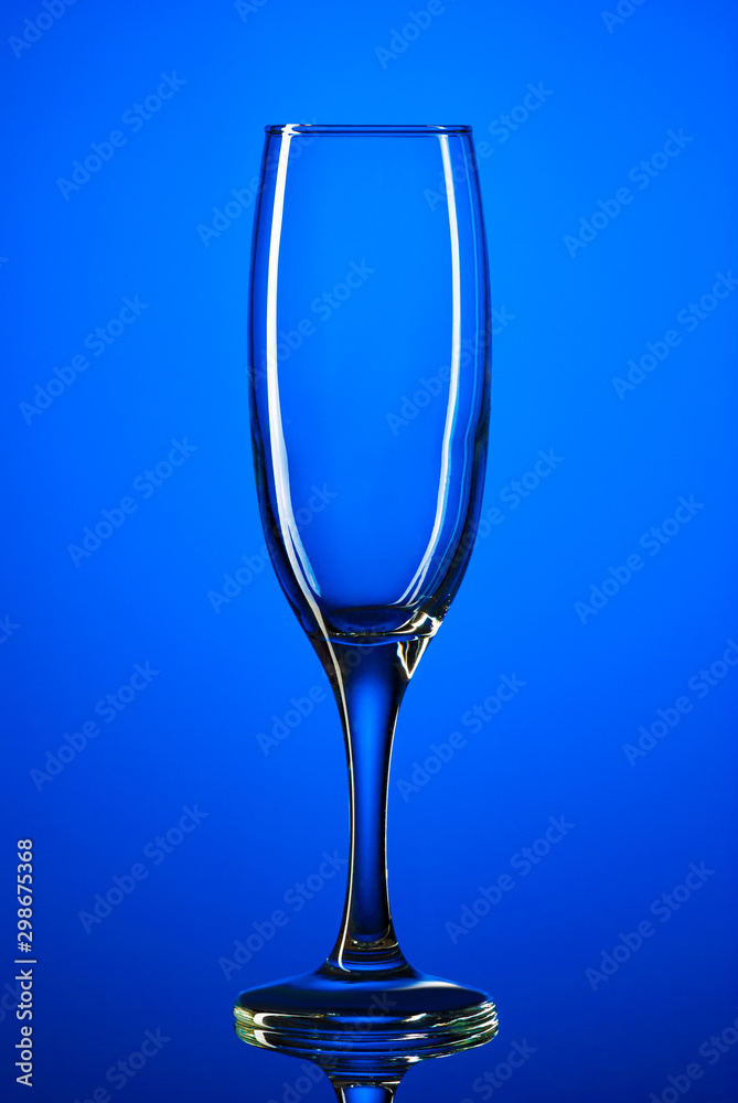 Glass goblet shot on a blue background close-up Glass goblet shot on a blue background close-up