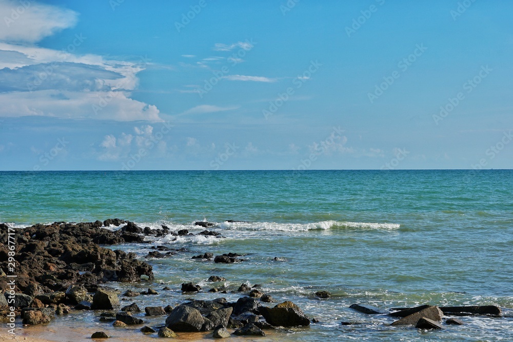 Rocks in the sea and blue sky as the background.