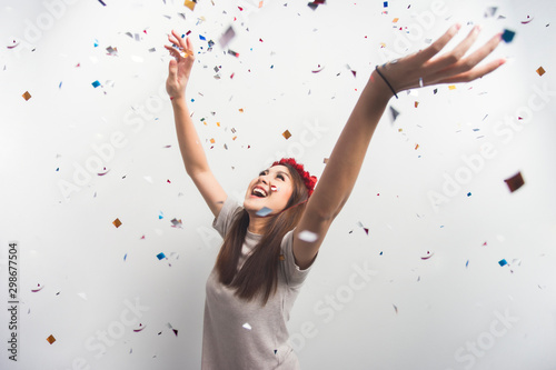 Asian girl fun celebrating Christmas or New Year party confetti. Young woman excited celebration party new year. Happy new year concept.
