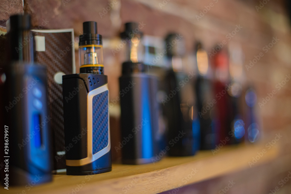 Electronic cigarette on a background of vape shop. E-cigarette for vaping. Electronic cigarette on a background of vape shop. E-cigarette for vaping.