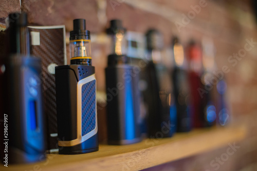 Electronic cigarette on a background of vape shop. E-cigarette for vaping.