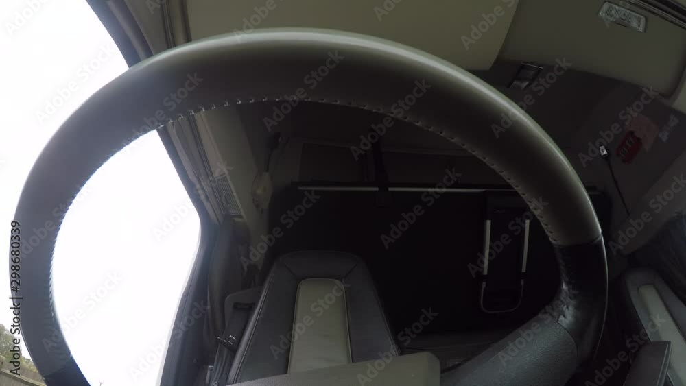In cab action cam view of a male HGV Driver, climbing into the cab and reversing the semi truck into a parking space. In cab action cam view of a male HGV Driver, climbing into the cab and reversing the semi truck into a parking space.