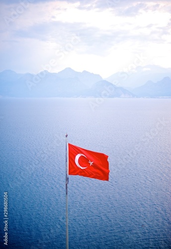 Fototapeta Naklejka Na Ścianę i Meble -  Turkish Flag In Mediterranean Sea With Mountains