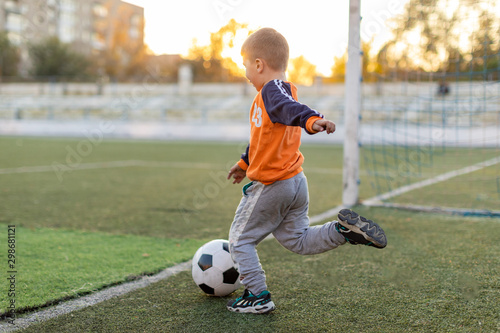 Young boy or kid plays soccer or football sports for exercise and activity.