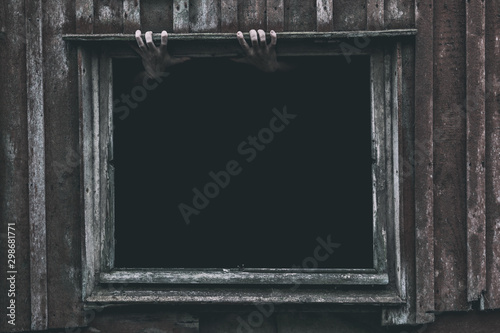 Two hands rising out from the old window ancient house, Halloween concept. photo