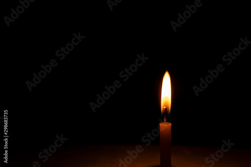 One candle that is shining in the dark