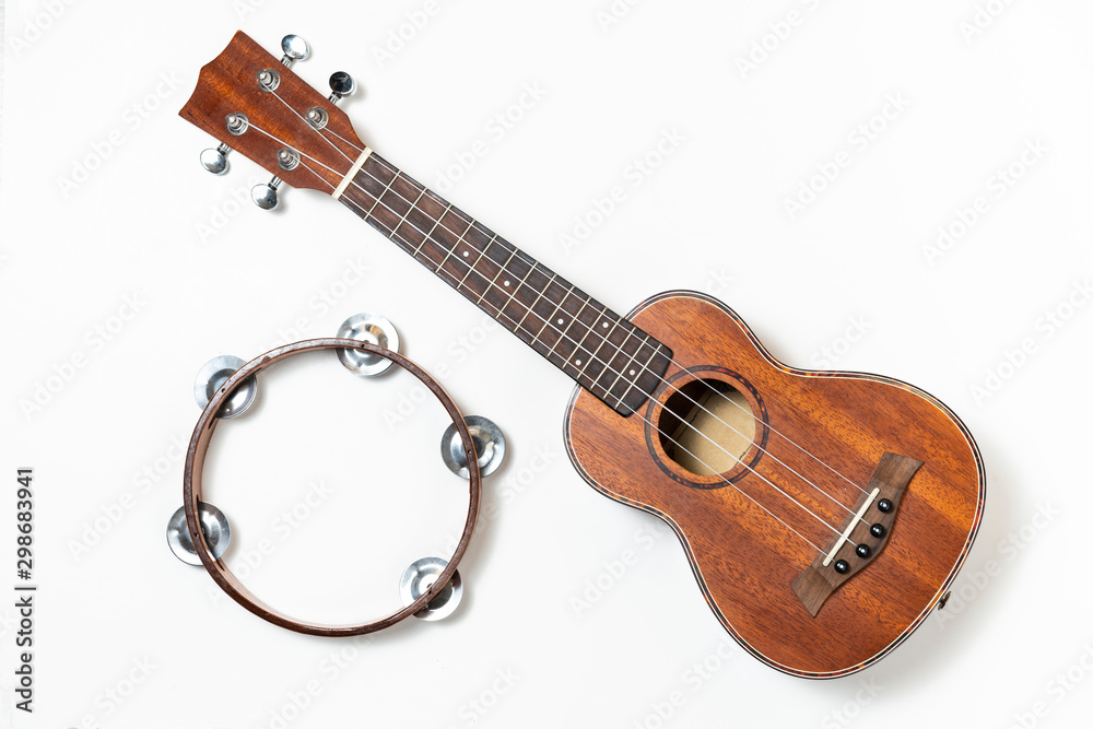 Fototapeta premium Ukulele and wooden tambourine. White background.