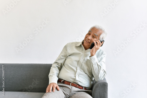 Obraz na płótnie Senior asian old man telephone call their children, Lonely grandfather talking with family on smartphone at home, Elderly old parent was abandoned by family. w salonie