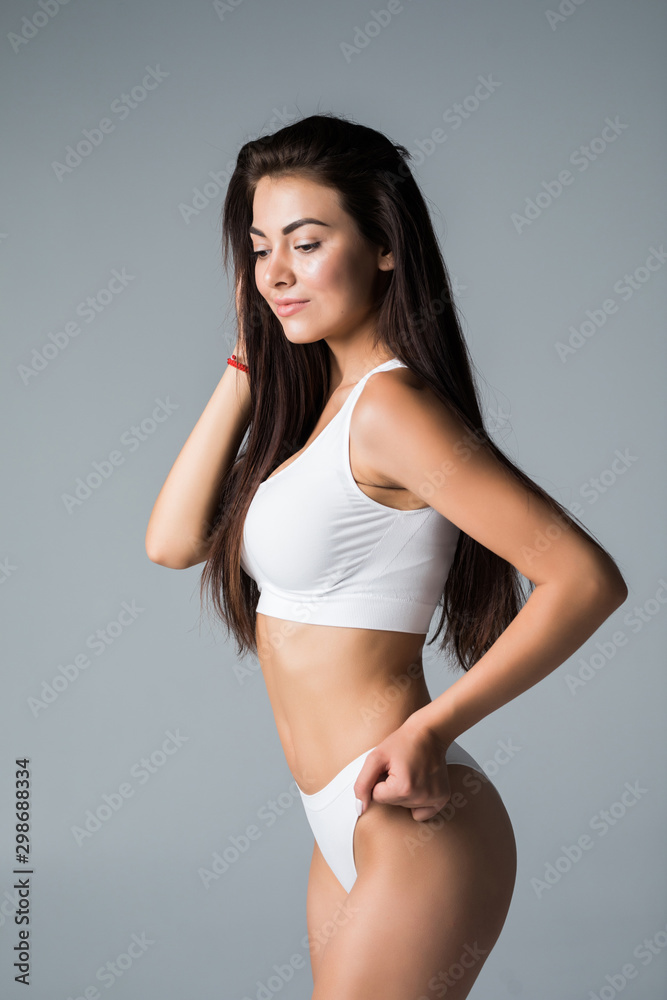 Obraz premium Body of young and beautiful woman in white underwear isolated on gray background