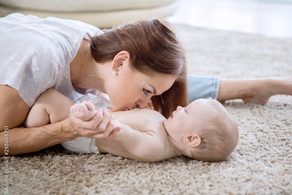 Caucasian woman kissing belly of her baby girl Caucasian woman kissing belly of her baby girl