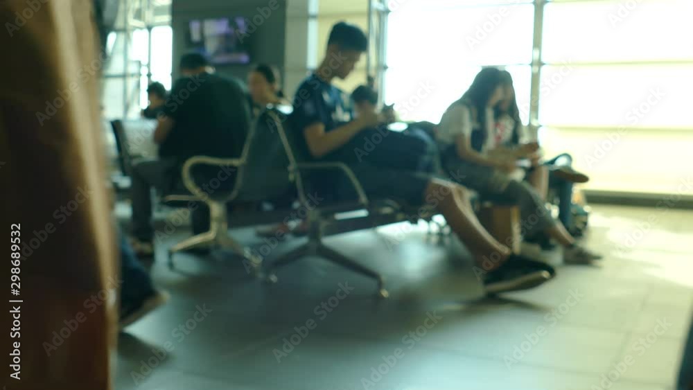 Defocused passengers in waiting area seats Defocused passengers in waiting area seats