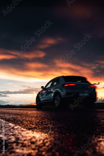 A car driving by after a heavy autumn rain with dramatic sunset light and colorful light