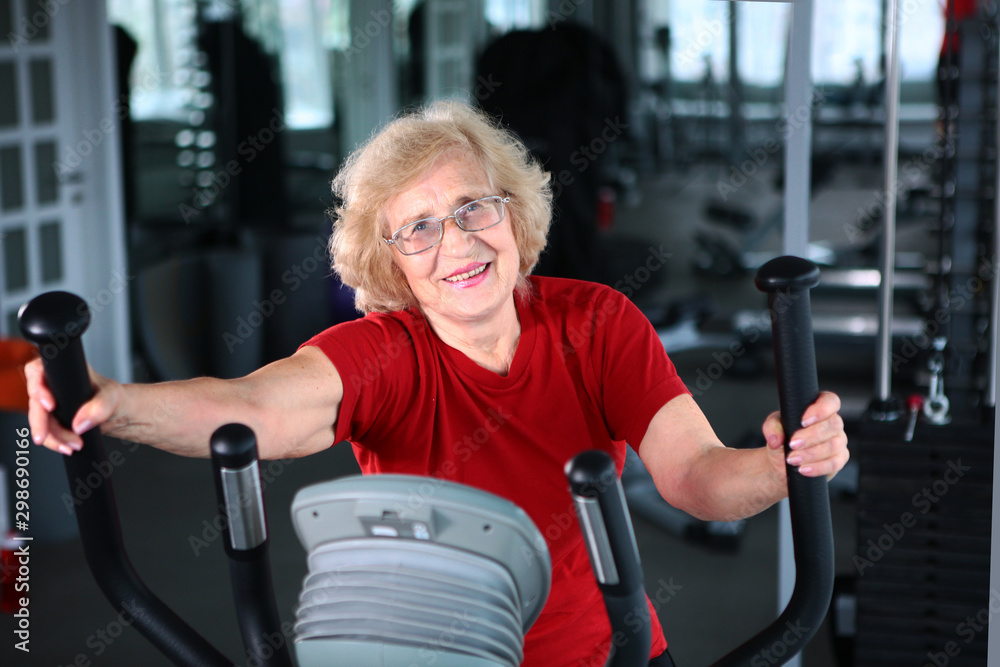 An elderly woman goes in for sports. Active life in old age. Healthy lifestyle concept. Portrait in the interior.
