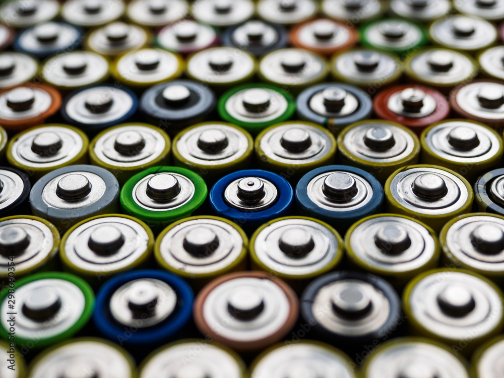 A large number of old AA batteries of different colors. A large number of old AA batteries of different colors.