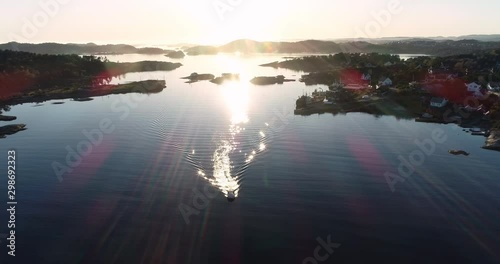 Drone flight towards boat during sunset in Langenes in south Norway. photo