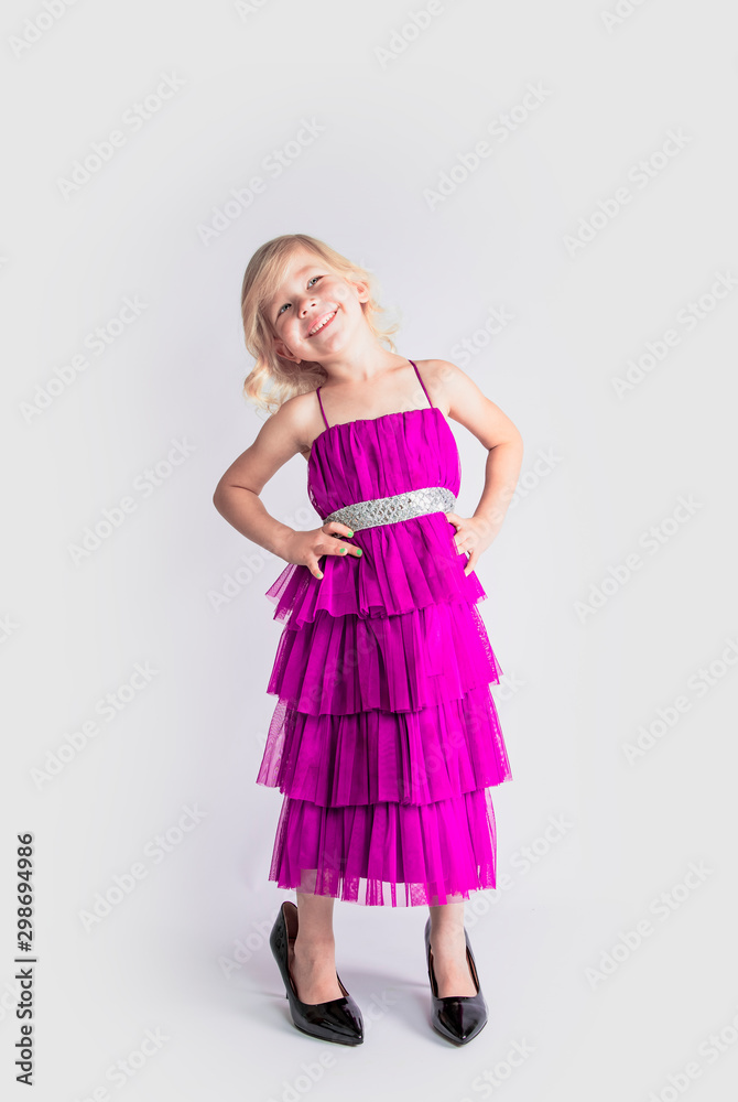 amazing girl in a blue retro dress and mother's patent leather high-heeled shoes smiling looks at the top. Isolated on a gray background. amazing girl in a blue retro dress and mother's patent leather high-heeled shoes smiling looks at the top. Isolated on a gray background.