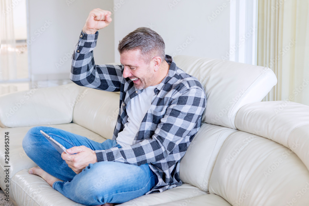 Handsome man expressing happy while uses tablet