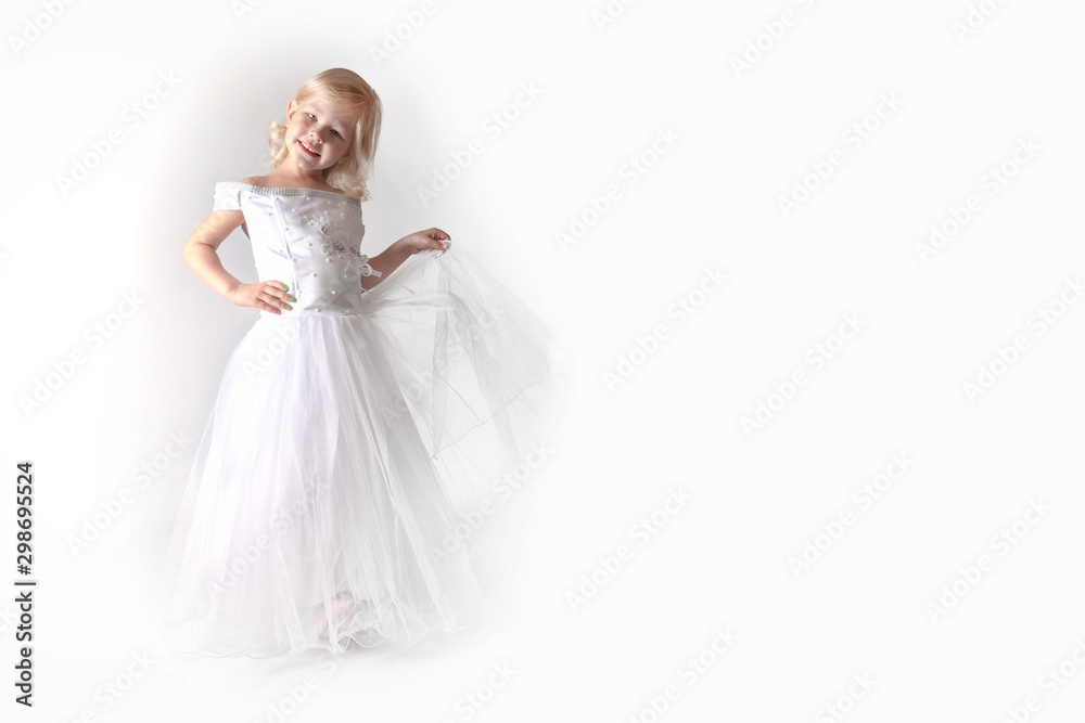 little girl in a wedding dress. pretty little girl in beautiful white dress isolated on light background. Copy space