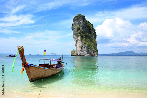 One Thai fishing boat tied up on the beach with a beautiful island in the background  Krabi  Thailand.