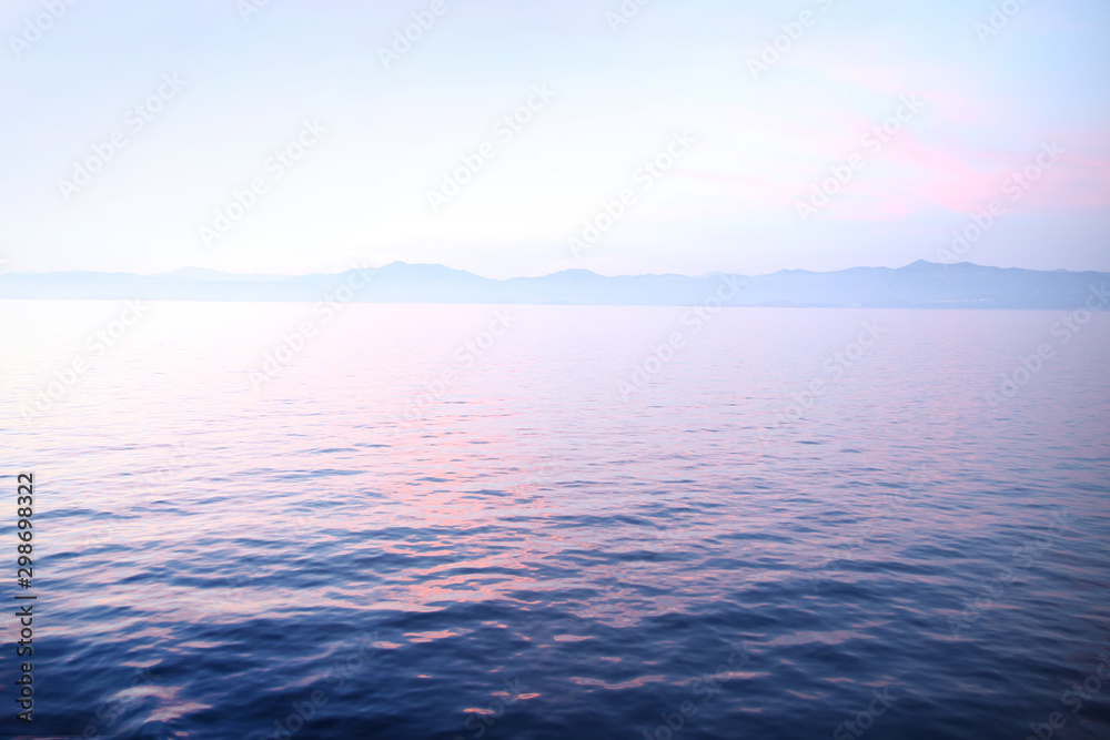View of sunset over the calm ocean looking towards the horizon. View of sunset over the calm ocean looking towards the horizon.