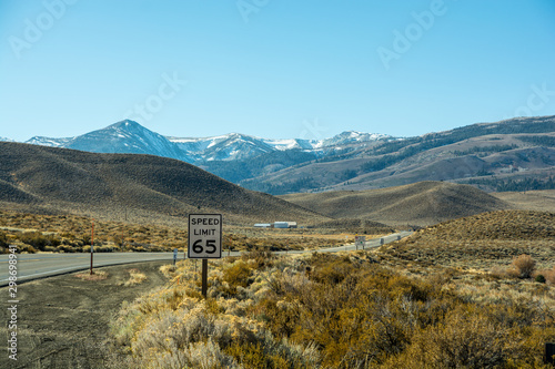 View to the country road. Sign of speed limit installed in beautiful place.