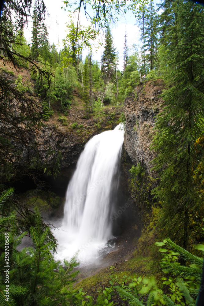 view of moul falls in wells gray provincial park, unique walk behind waterfall in canada after long hike