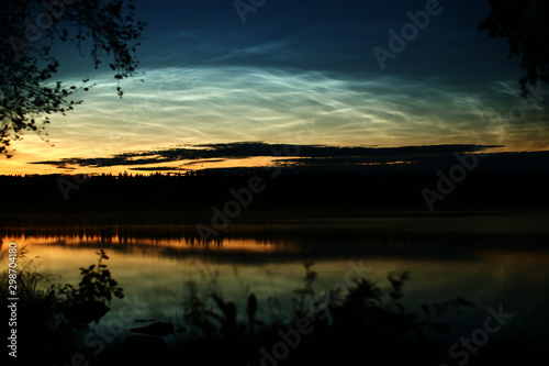 Illuminated cirrus clouds at dusk over lake Malgomaj in Vasterbotten, Sweden