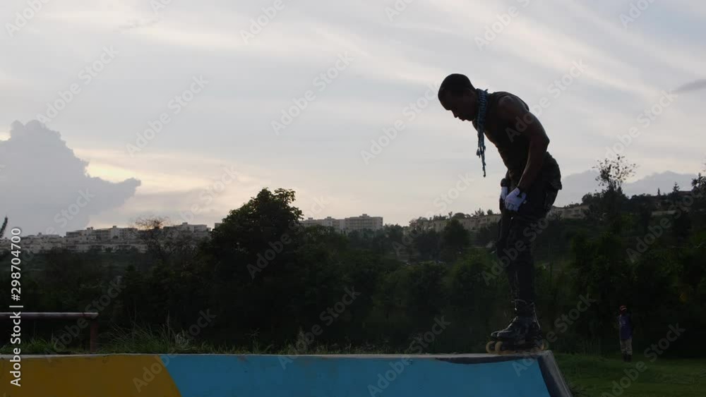 silhouette of man jumping with rollerblades on the ramp in at the park silhouette of man jumping with rollerblades on the ramp in at the park